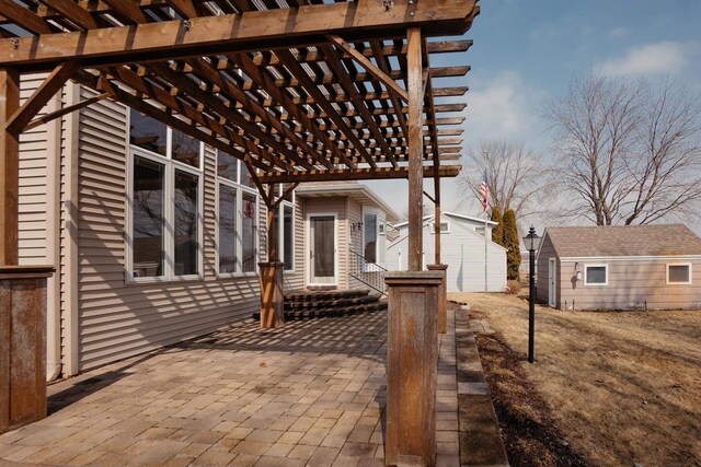 view of patio / terrace with an outbuilding, a pergola, and a storage shed