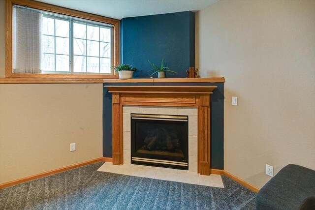 details with baseboards, a tiled fireplace, and carpet flooring