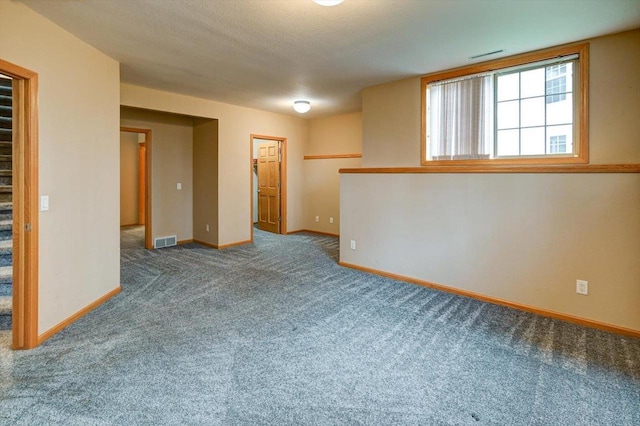 spare room with baseboards, visible vents, and carpet flooring