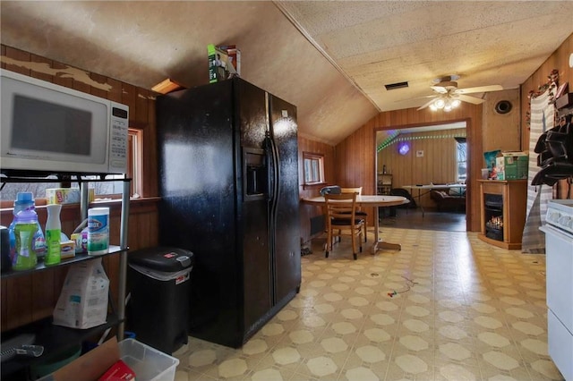 905 Lewis Ave, Cameron, WI 54822 - kitchen featuring vaulted ceiling, wood walls, light floors, white appliances, and ceiling fan