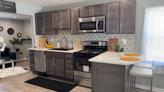 33110 Store St, Burlington, WI 53105 - kitchen with a sink, dark brown cabinetry, appliances with stainless steel finishes, and decorative backsplash