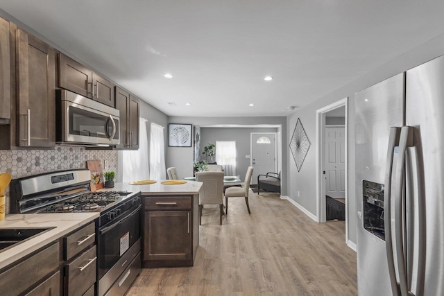 33110 Store St, Burlington, WI 53105 - kitchen with light countertops, light wood-style flooring, tasteful backsplash, dark brown cabinetry, and appliances with stainless steel finishes