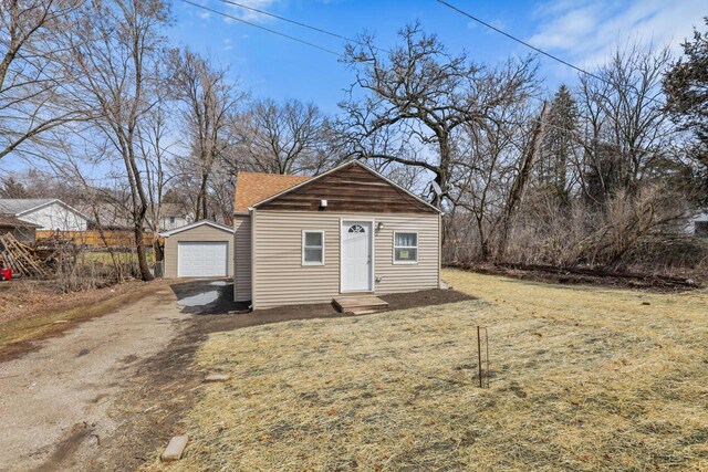 33110 Store St, Burlington, WI 53105 - view of front of house with an outdoor structure, a garage, a front lawn, entry steps, and dirt driveway
