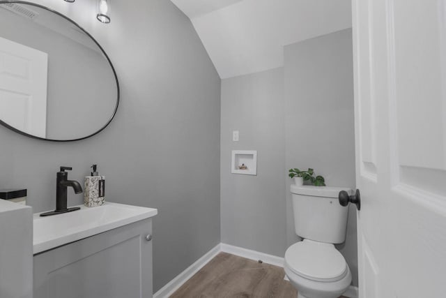 33110 Store St, Burlington, WI 53105 - half bath with visible vents, baseboards, toilet, vanity, and vaulted ceiling
