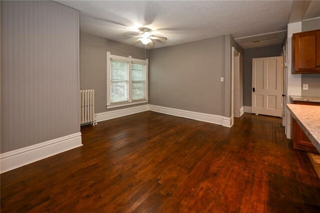 301 Summit St, Spooner, WI 54801 - interior space with radiator heating unit, a textured ceiling, baseboards, ceiling fan, and dark wood-style flooring