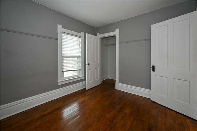 301 Summit St, Spooner, WI 54801 - unfurnished bedroom featuring a closet, hardwood / wood-style flooring, and baseboards