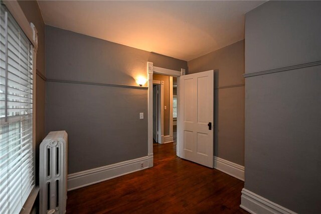 301 Summit St, Spooner, WI 54801 - corridor featuring baseboards, wood finished floors, and radiator heating unit