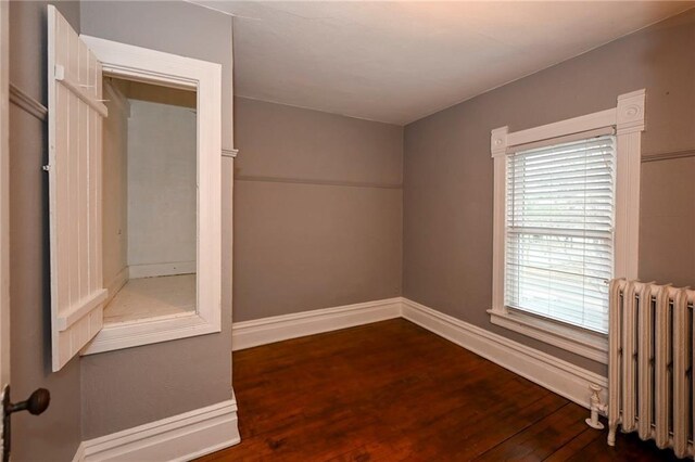 301 Summit St, Spooner, WI 54801 - unfurnished room featuring baseboards, wood finished floors, and radiator heating unit