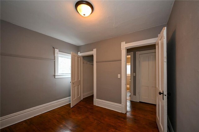 301 Summit St, Spooner, WI 54801 - unfurnished bedroom with baseboards, a closet, and wood finished floors