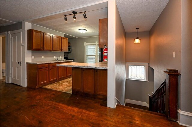 301 Summit St, Spooner, WI 54801 - kitchen featuring dark wood-style flooring, a textured ceiling, stainless steel microwave, range with electric stovetop, and brown cabinetry