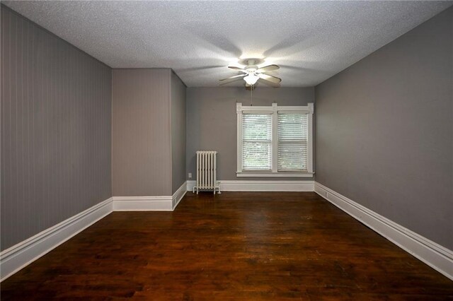 301 Summit St, Spooner, WI 54801 - unfurnished room featuring radiator, baseboards, a textured ceiling, a ceiling fan, and wood finished floors