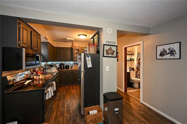 301 Summit St, Spooner, WI 54801 - kitchen featuring dark wood-type flooring, a textured ceiling, baseboards, and appliances with stainless steel finishes