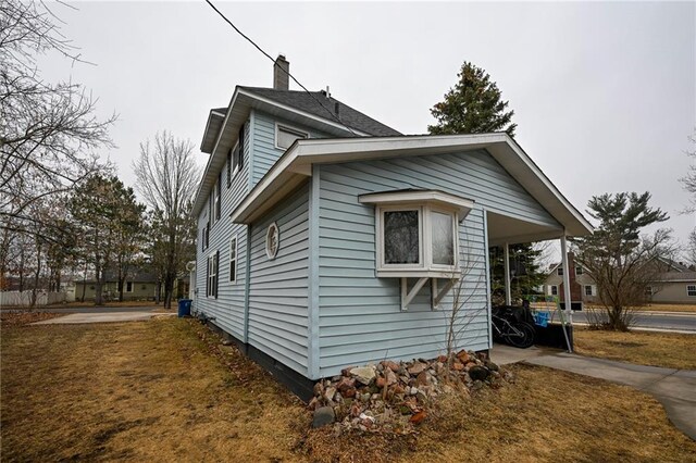 301 Summit St, Spooner, WI 54801 - view of property exterior with a lawn and a chimney