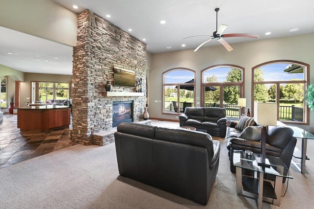 7548 Fallen Oak Dr, Verona, WI 53593 - living room featuring a stone fireplace, recessed lighting, arched walkways, ceiling fan, and carpet