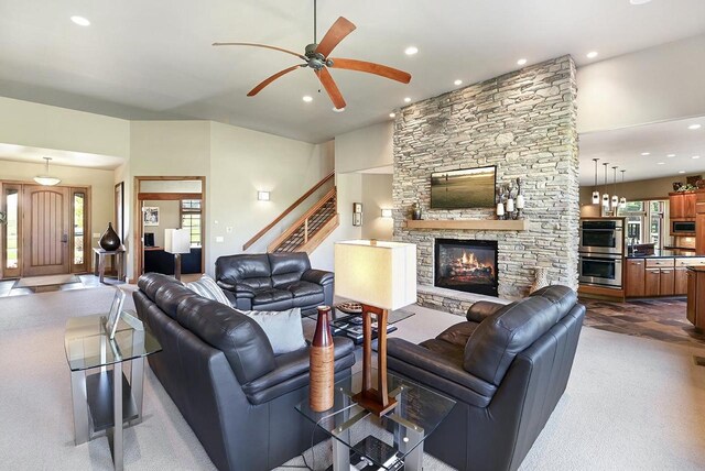 7548 Fallen Oak Dr, Verona, WI 53593 - living area with a stone fireplace, stairway, a ceiling fan, and plenty of natural light