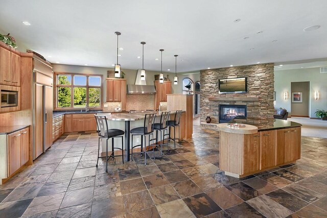 7548 Fallen Oak Dr, Verona, WI 53593 - kitchen with open floor plan, a large island with sink, decorative backsplash, wall chimney range hood, and stone tile flooring
