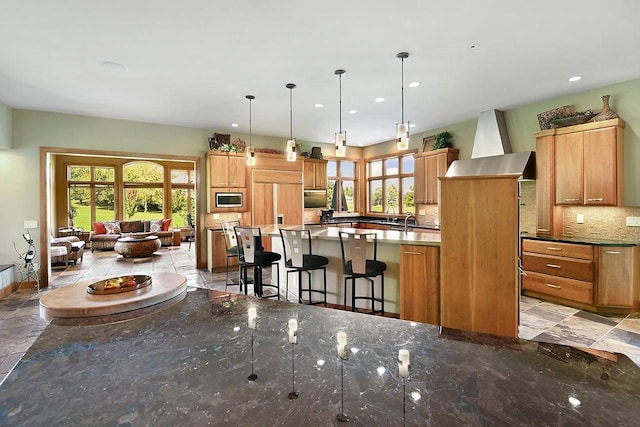 7548 Fallen Oak Dr, Verona, WI 53593 - kitchen with decorative backsplash, a wealth of natural light, an island with sink, and built in appliances