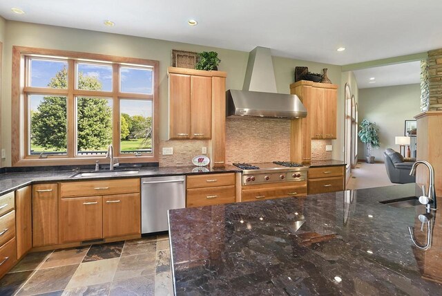 7548 Fallen Oak Dr, Verona, WI 53593 - kitchen featuring wall chimney range hood, appliances with stainless steel finishes, a sink, and dark stone counters