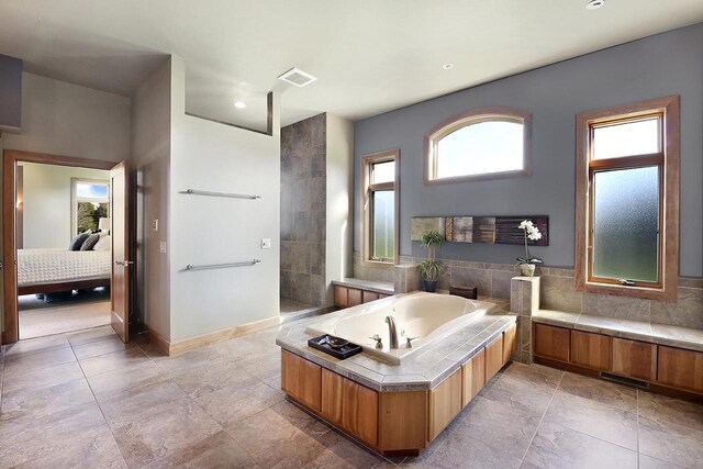 7548 Fallen Oak Dr, Verona, WI 53593 - ensuite bathroom featuring a bath, visible vents, walk in shower, baseboards, and ensuite bath