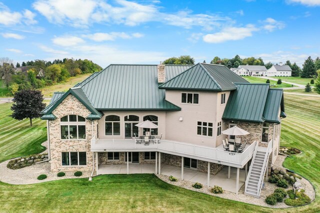 7548 Fallen Oak Dr, Verona, WI 53593 - back of house with a standing seam roof, metal roof, a deck, a patio area, and a lawn