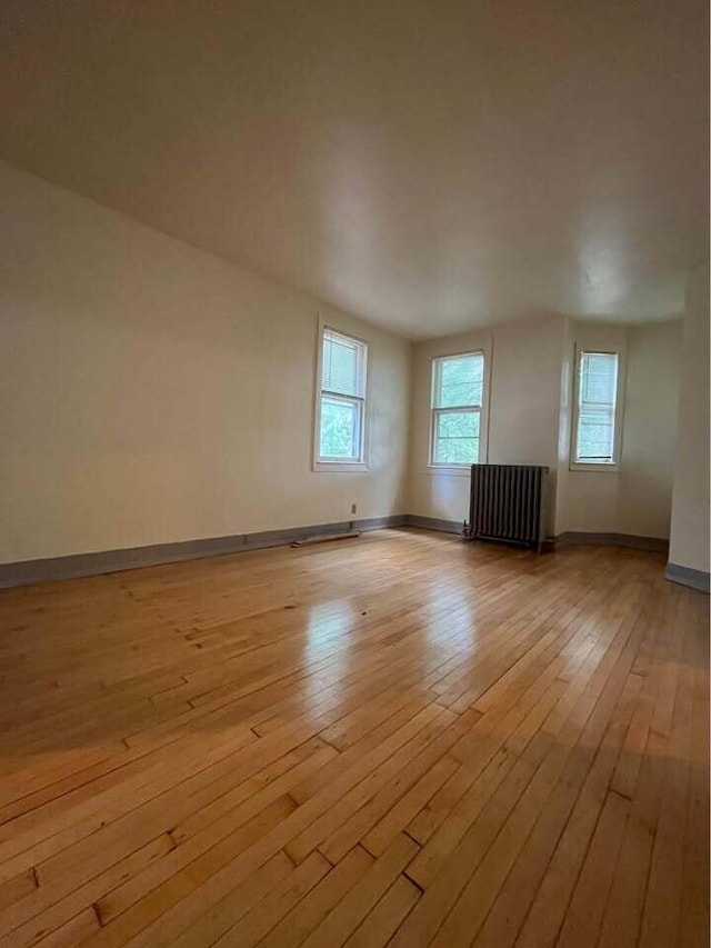 3034 W State St Unit 3036, Milwaukee, WI 53208 - unfurnished room featuring radiator, light wood-style floors, and baseboards