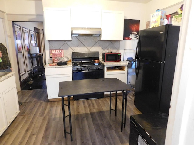 3007 N 29th St, Milwaukee, WI 53210 - kitchen featuring tasteful backsplash, range hood, white cabinets, black appliances, and wood finished floors