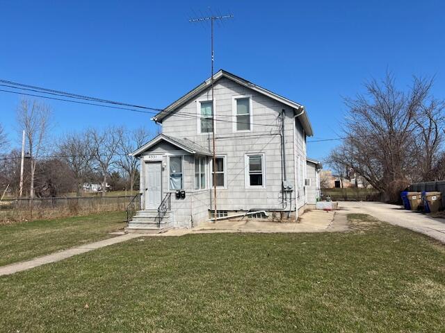 view of front facade featuring fence, a front lawn, and entry steps