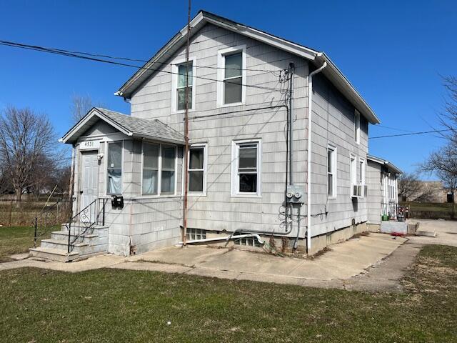 rear view of house featuring a lawn