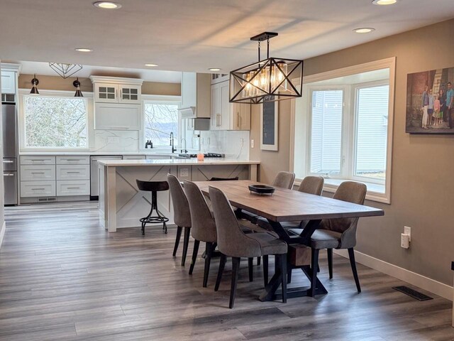 dining area with baseboards, visible vents, wood finished floors, and recessed lighting