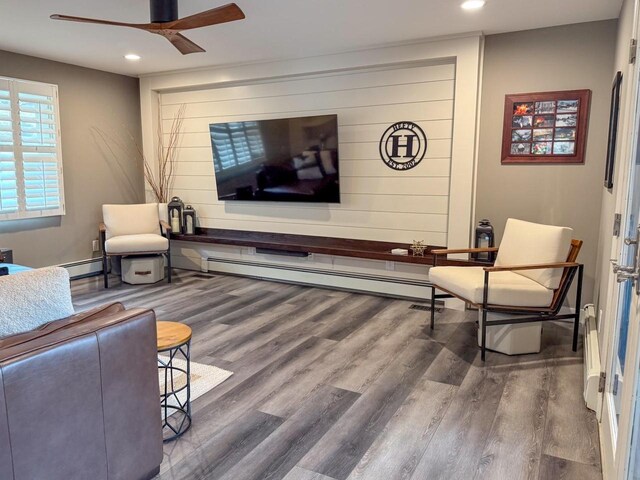 living room with baseboard heating, wood finished floors, recessed lighting, and a ceiling fan
