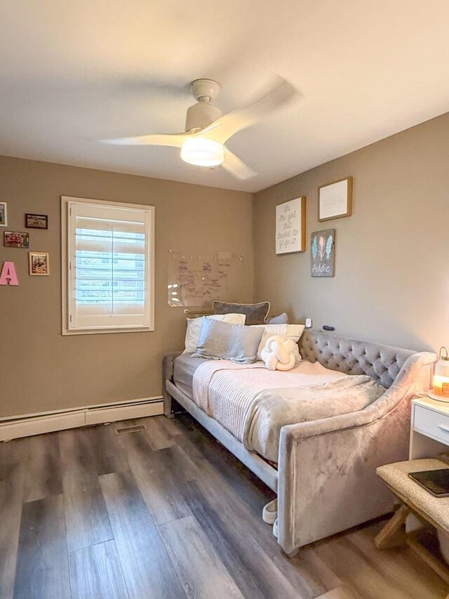 bedroom featuring baseboards, ceiling fan, wood finished floors, and a baseboard heating unit
