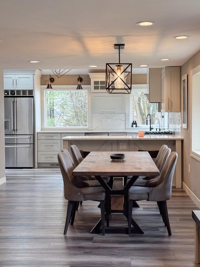 dining space with recessed lighting, plenty of natural light, baseboards, and wood finished floors