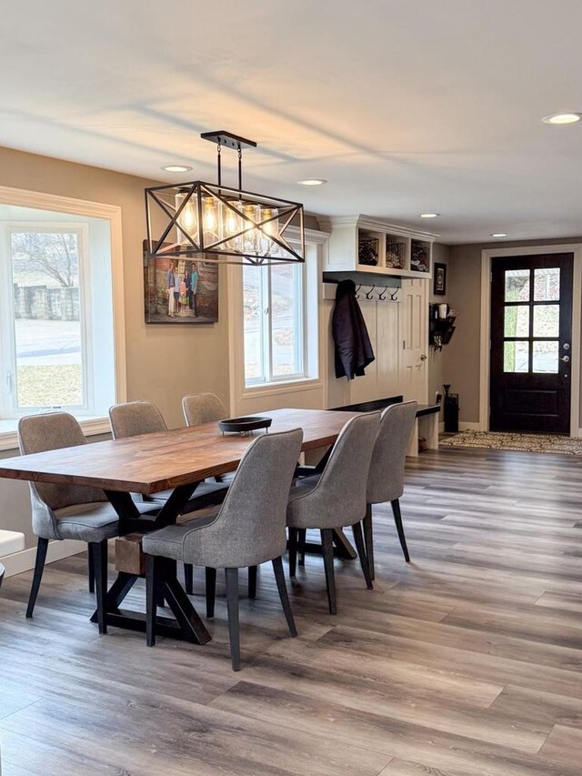 dining room with plenty of natural light, light wood finished floors, and an inviting chandelier