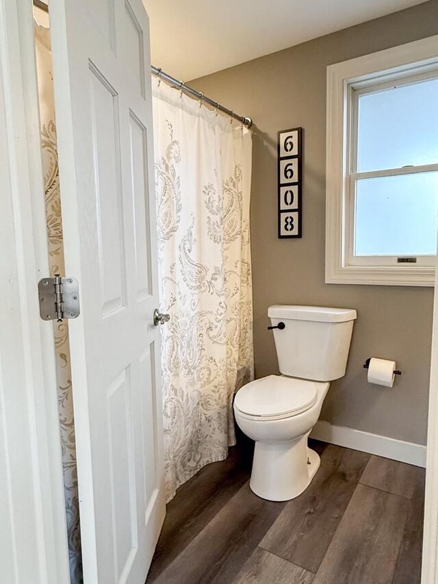 full bath featuring toilet, baseboards, and wood finished floors