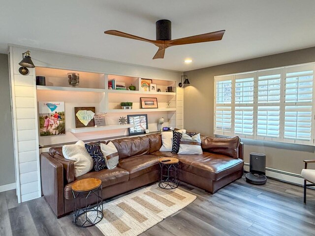 living area with a baseboard radiator, ceiling fan, and wood finished floors