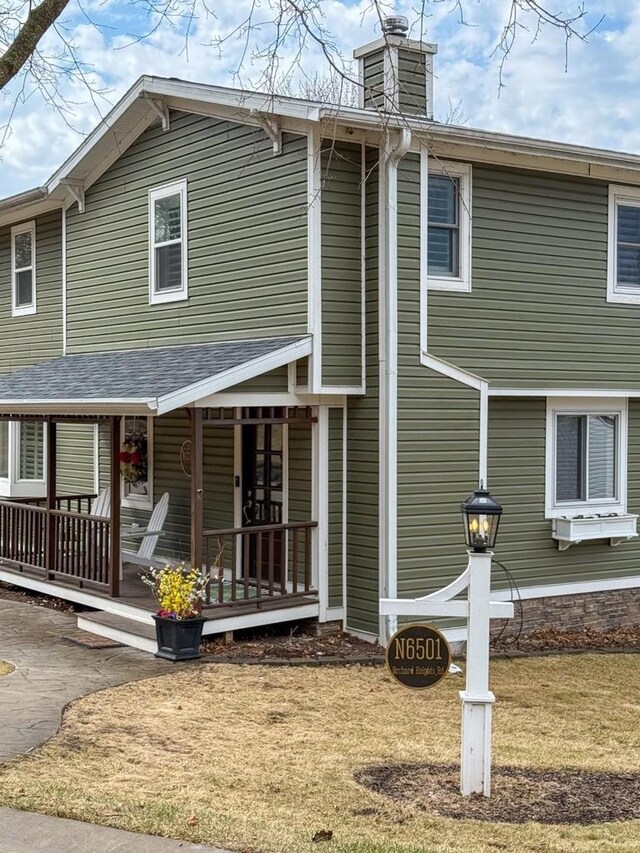 view of front of property featuring covered porch and a chimney