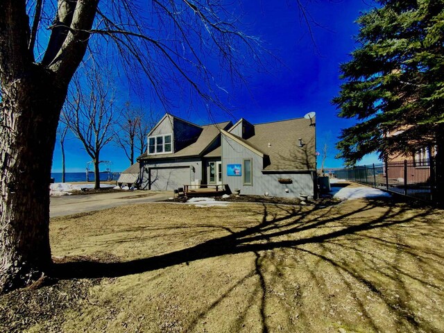 W4862 Swan Acre Dr, Cecil, WI 54111 - view of front of home with driveway, an attached garage, fence, and a water view