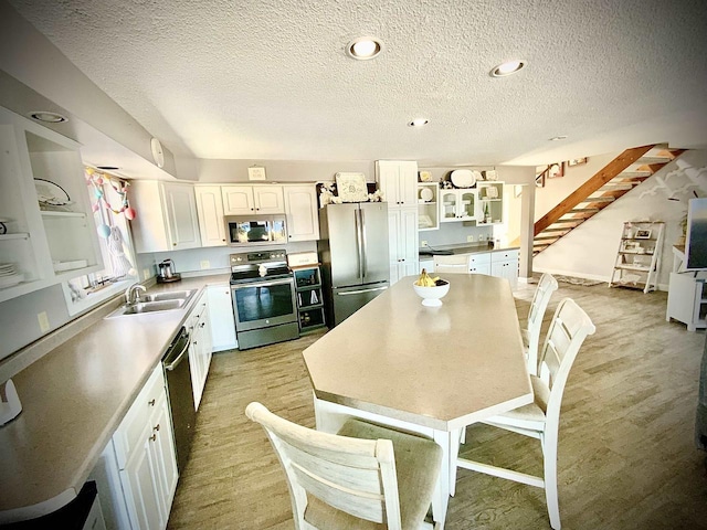 W4862 Swan Acre Dr, Cecil, WI 54111 - kitchen featuring open shelves, stainless steel appliances, a sink, light wood-style floors, and white cabinets