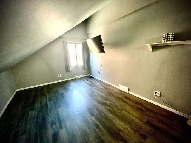 W4862 Swan Acre Dr, Cecil, WI 54111 - bonus room with dark wood-style floors, visible vents, baseboards, and vaulted ceiling