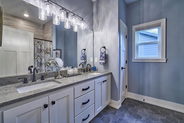 2721 Woodfield Ct, Howard, WI 54313 - bathroom featuring double vanity, baseboards, a sink, and tile patterned flooring