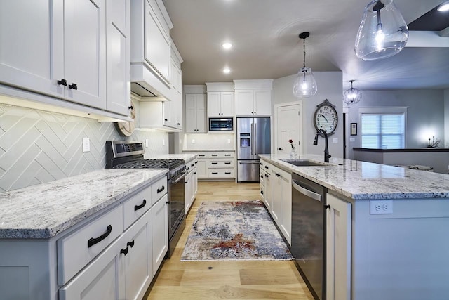 2721 Woodfield Ct, Howard, WI 54313 - kitchen featuring decorative backsplash, a sink, pendant lighting, light wood-style flooring, and appliances with stainless steel finishes