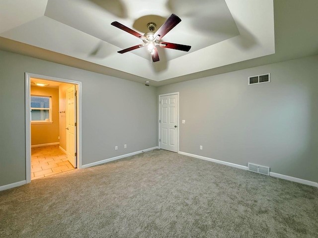 2208 W Milwaukee St, Stoughton, WI 53589 - unfurnished bedroom with baseboards, visible vents, carpet, and a raised ceiling