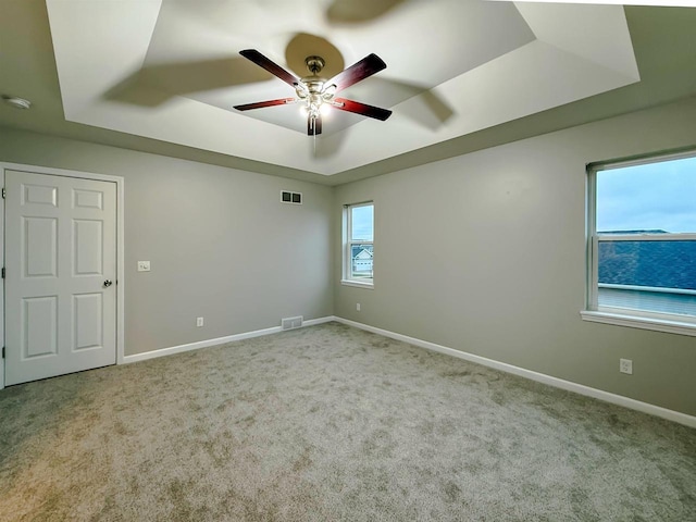 2208 W Milwaukee St, Stoughton, WI 53589 - carpeted spare room featuring baseboards, visible vents, a ceiling fan, and a raised ceiling