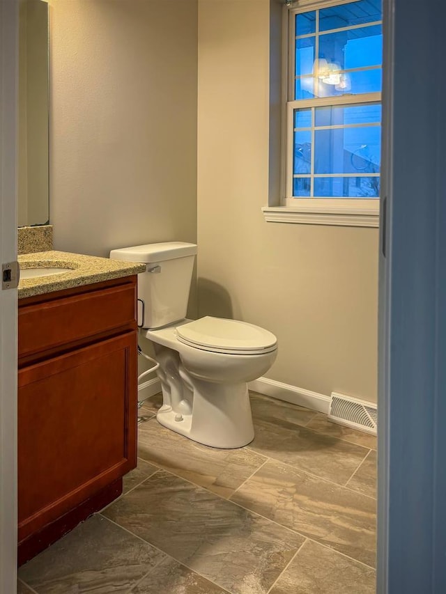2208 W Milwaukee St, Stoughton, WI 53589 - half bath with baseboards, visible vents, toilet, and vanity