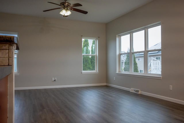 2208 W Milwaukee St, Stoughton, WI 53589 - unfurnished room with visible vents, dark wood-type flooring, baseboards, and ceiling fan