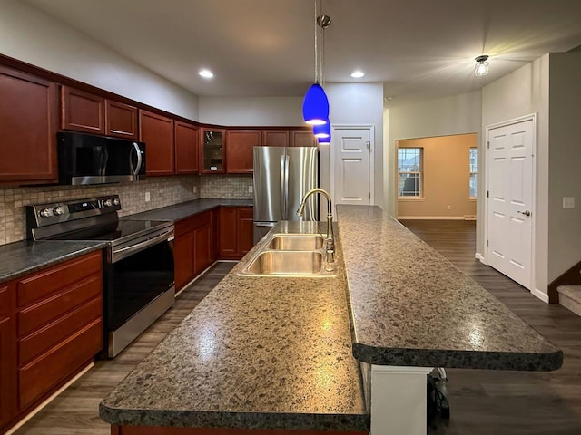 2208 W Milwaukee St, Stoughton, WI 53589 - kitchen with a sink, stainless steel appliances, backsplash, and a center island with sink