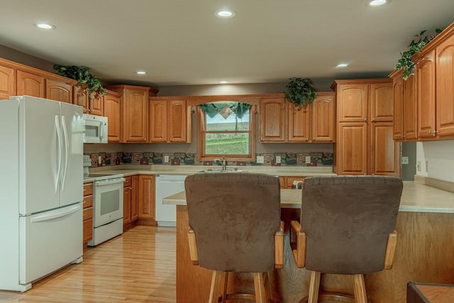5995 Section Line Rd, Dodgeville, WI 53533 - kitchen featuring white appliances, a kitchen bar, recessed lighting, light countertops, and a sink