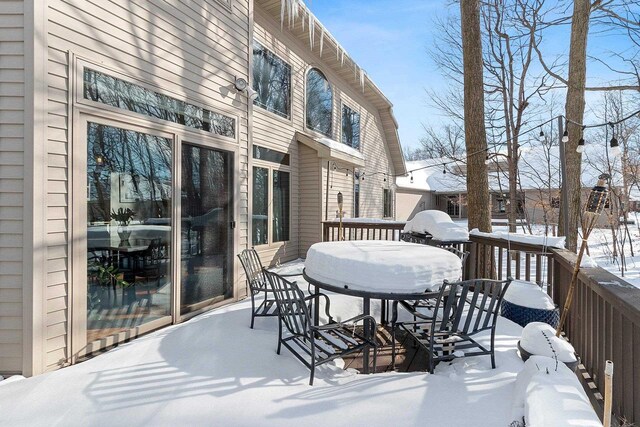 snow covered deck featuring outdoor dining space