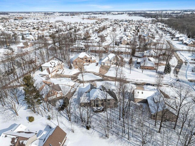 snowy aerial view with a residential view