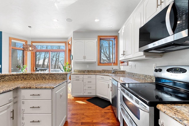 kitchen featuring a sink, recessed lighting, white cabinetry, wood finished floors, and stainless steel appliances